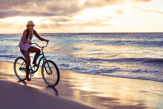 在海滩上骑车的女人