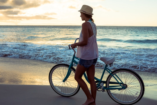 在海滩上骑自行车的女人