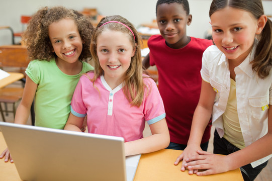 微笑的小学生使用笔记本电脑