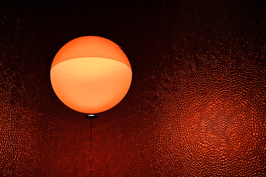 深红色毛玻璃背景墙和橙色圆形灯