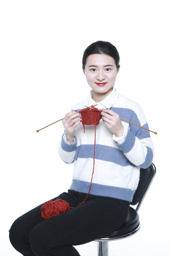 坐着织棉线的年轻女孩