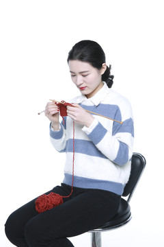 坐着织棉线的年轻女孩