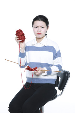 坐着织棉线的年轻女孩