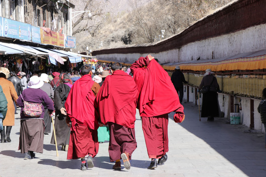 三位喇嘛在布达拉宫下面行走