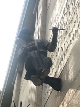 雕琢墙壁的工人雕像