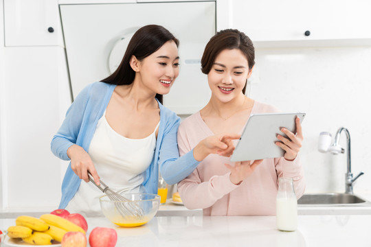 年轻女子在厨房边做饭边和朋友聊天