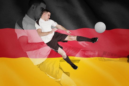 足球运动员在德国国旗上踢球