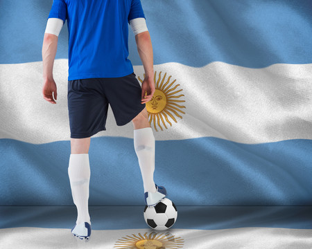 阿根廷国旗上足球运动员持球站立