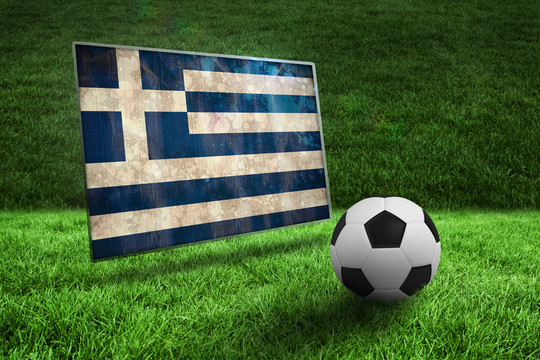 草地上的黑白足球对抗希腊国旗，