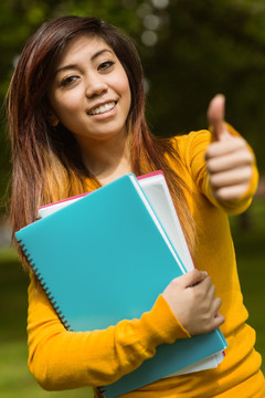 公园里带书微笑的女大学生