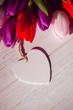 木桌上的郁金香和心形牌子