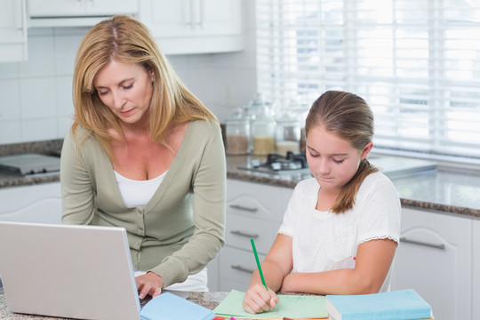 快乐的母亲帮助女儿做家庭作业