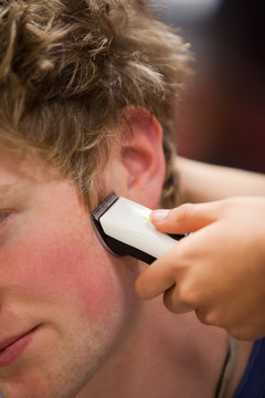 一个年轻人用理发刀理发的照片