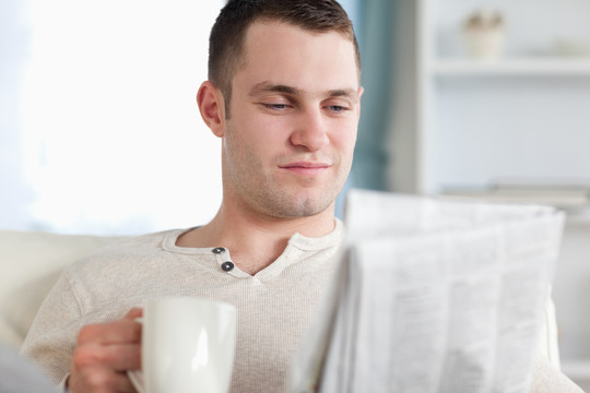 男人在客厅里看新闻时喝咖啡
