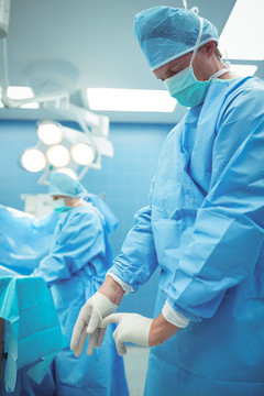 男外科医生在手术室摘除手术手套