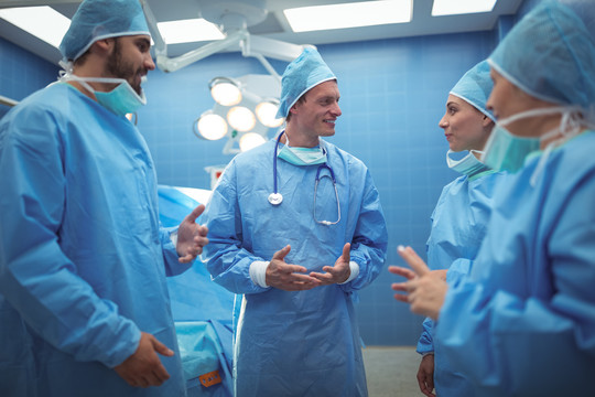 在手术室讨论的外科医生小组