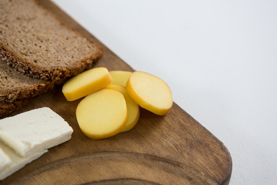 木板上的各种奶酪和棕色面包