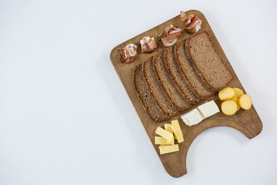 木板上的各种奶酪和棕色面包