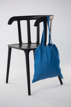 蓝包挂在白底黑椅子上