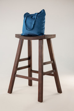 白底木凳上的蓝色袋子