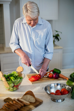 厨房里准备沙拉蔬菜的老人