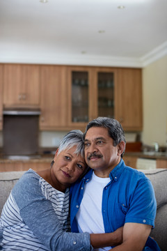 老年夫妇在家客厅相互拥抱的照片