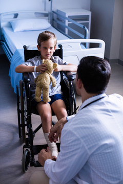 男医生在医院病房与儿童患者互动