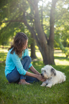 女士与宠物狗坐在草坪上