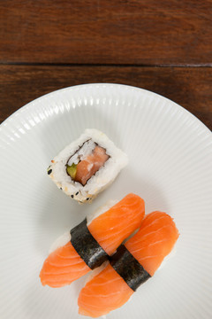 寿司用白色圆板盛在木桌上