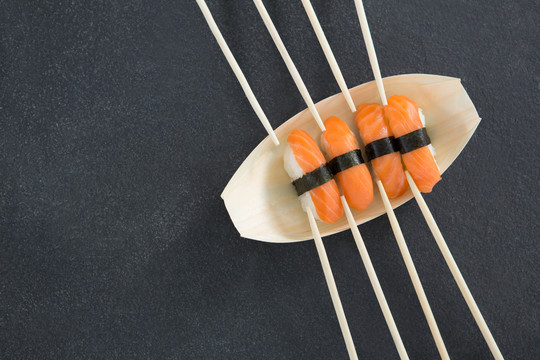 用筷子在船形盘子上做寿司特写