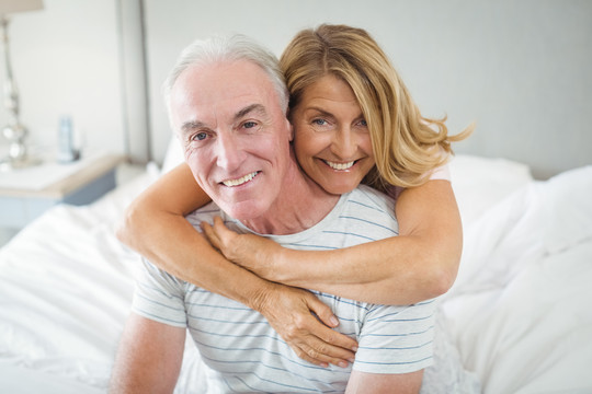 幸福的老年夫妇在床上拥抱