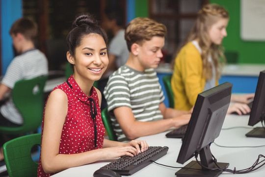 微笑的学生在学校的电脑教室学习
