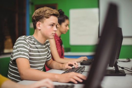 微笑的学生在学校的电脑教室学习