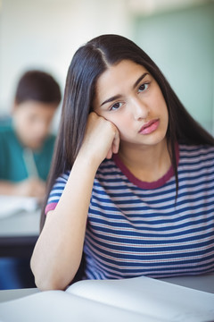 女生在学校实验室拿显微镜的照片