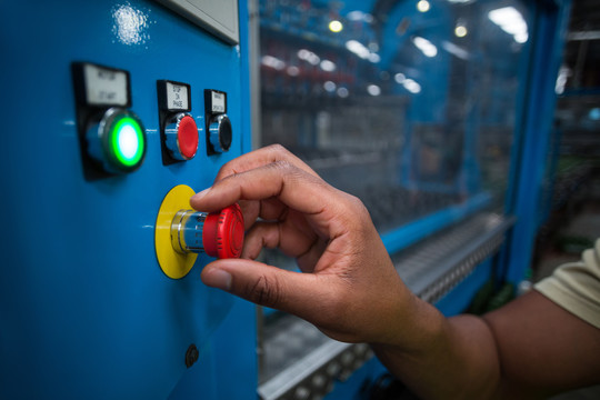 工厂工人在工厂按下的绿色按钮