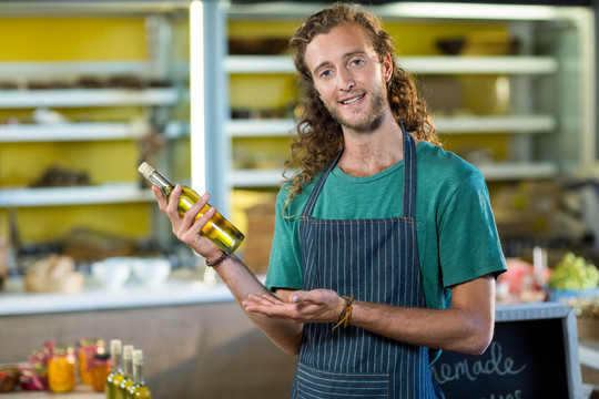 商店助理为顾客提供橄榄油瓶