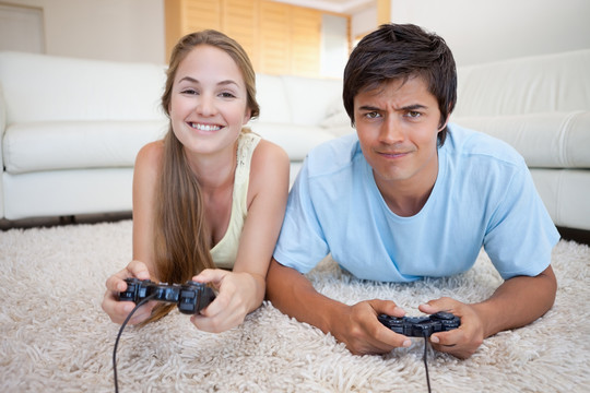 在客厅里玩电子游戏的夫妻