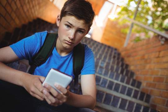 小学生在学校走廊使用手机