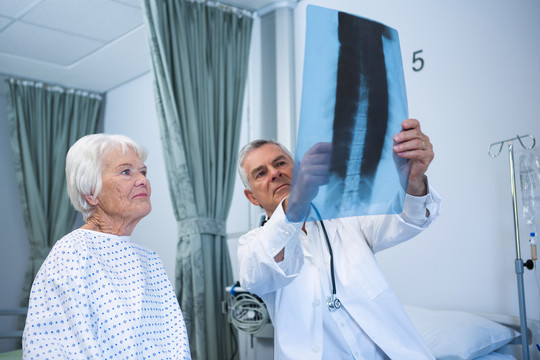 医生与住院老年患者讨论X光报告