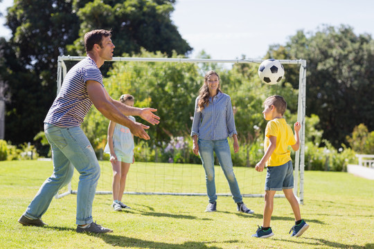 快乐的一家人在公园里踢足球