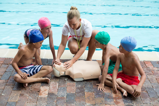 游泳池指导儿童时女救生员吹口哨
