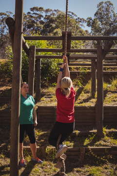 障碍训练中练习爬绳的女性