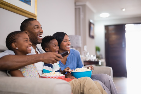在家看电视时吃爆米花的快乐家庭