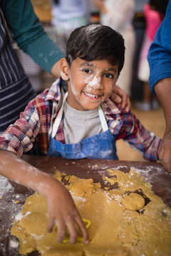 微笑男孩在家厨房做饭的照片