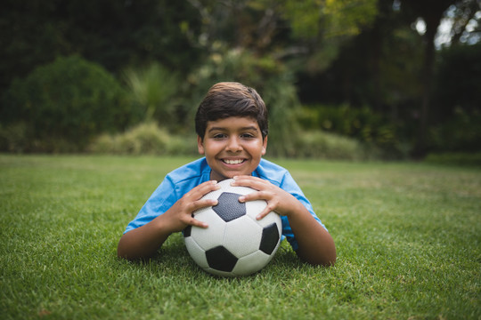 一个带足球的微笑男孩的画像