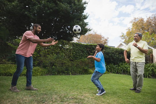 微笑的多代家庭在公园一起玩足球