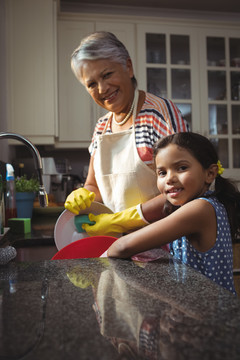 外婆和孙女洗涤餐具的图像