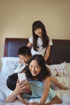 快乐家庭在卧室里使用手机