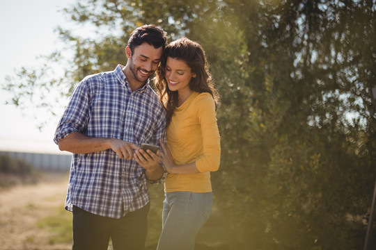 微笑的年轻夫妇在橄榄农场自拍