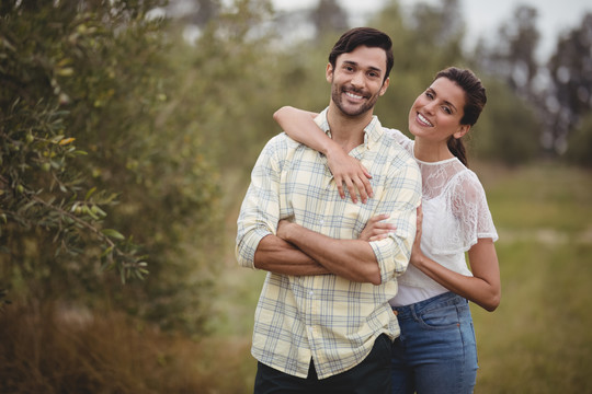 年轻夫妇站在橄榄农场的照片